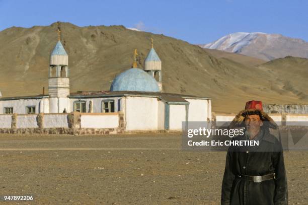 KAZAKH IN FRONT OF THE TOLBO MOSQUE, ALTAI RANGE, BAYAN OLGII PROVINCE, MONGOLIA.