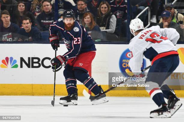 Ian Cole of the Columbus Blue Jackets skates with the puck as Jakub Vrana of the Washington Capitals defends during the first period in Game Three of...