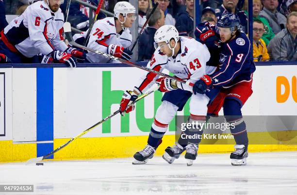 Tom Wilson of the Washington Capitals and Artemi Panarin of the Columbus Blue Jackets battle for control of the puck during the first period in Game...