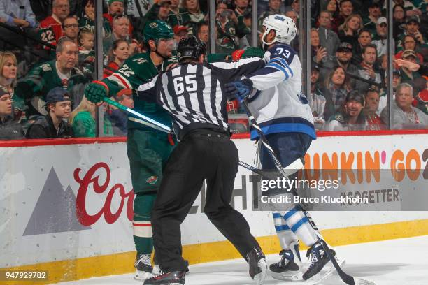 Nino Niederreiter of the Minnesota Wild and Dustin Byfuglien of the Winnipeg Jets are separated by an official in Game Four of the Western Conference...