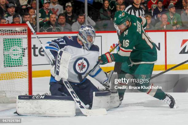 Connor Hellebuyck of the Winnipeg Jets makes a save against Jason Zucker of the Minnesota Wild in Game Four of the Western Conference First Round...