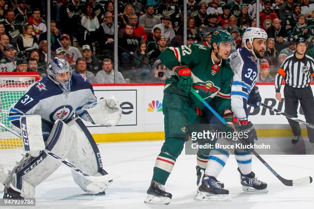 Dustin Byfuglien and Connor Hellebuyck of the Winnipeg Jets defend their goal against Nino Niederreiter of the Minnesota Wild in Game Four of the...
