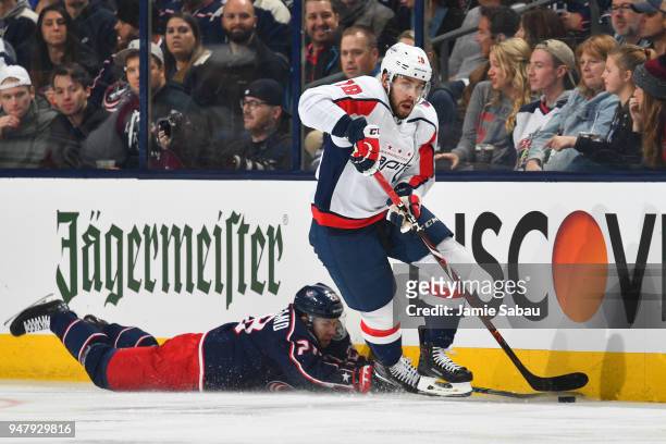 Chandler Stephenson of the Washington Capitals skates the puck away from Oliver Bjorkstrand of the Columbus Blue Jackets during the second period in...