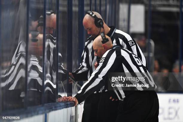 Linesmen Matt MacPherson and Darren Gibbs review an offside challenge during the second period between the Columbus Blue Jackets and the Washington...