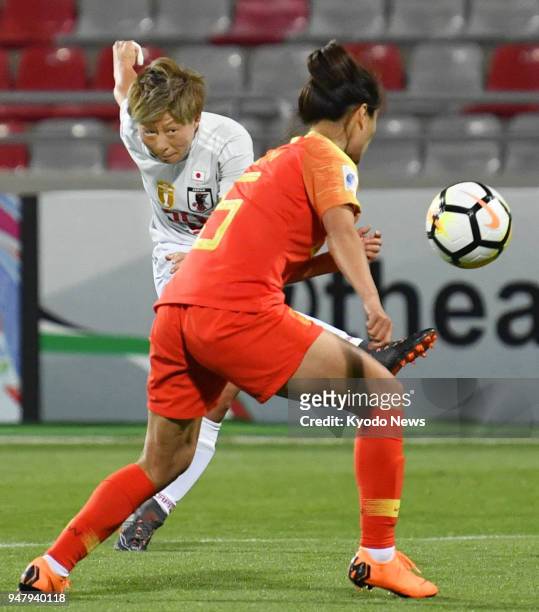 Japan forward Kumi Yokoyama scores her side's second goal past Wu Haiyan of China during the second half of a Women's Asian Cup match in Jordan on...