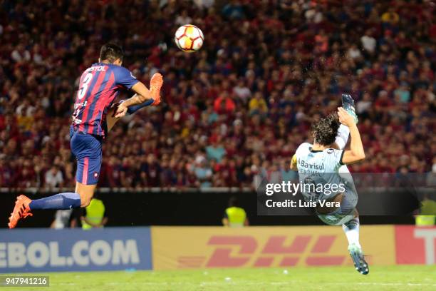 Pedro Geromel of Gremio fights for the ball with Marcos Caceres of Cerro Porteño during a match between Cerro Porteño and Gremio as part of Copa...