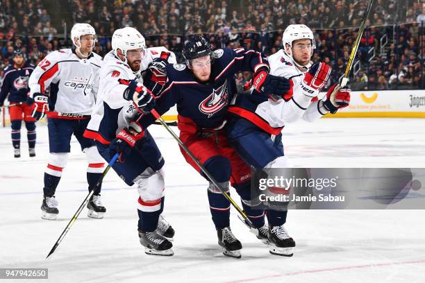 Pierre-Luc Dubois of the Columbus Blue Jackets battles for position with Michal Kempny and Tom Wilson of the Washington Capitals as they skate after...