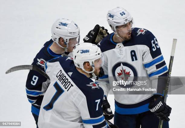 Andrew Copp and Matt Cullen of the Minnesota Wild congratulate teammate Mark Scheifele on an empty net goal against the Minnesota Wild during the...