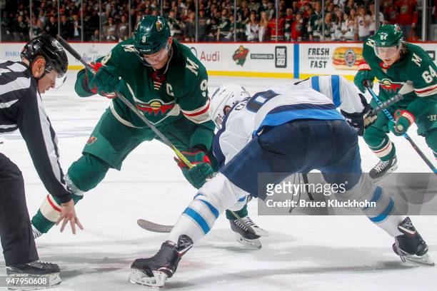 Mikko Koivu of the Minnesota Wild takes a faceoff against Andrew Copp of the Winnipeg Jets in Game Four of the Western Conference First Round during...