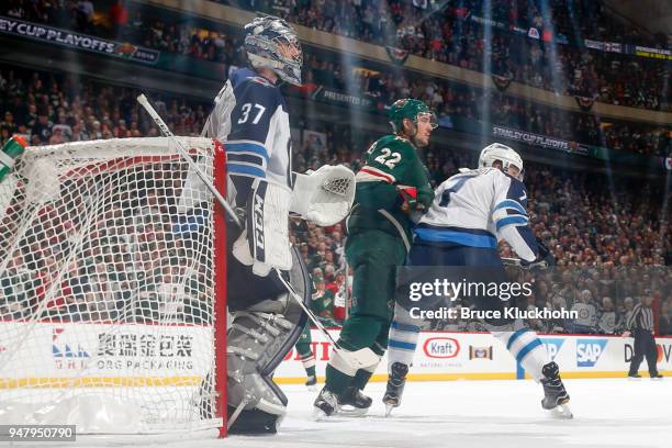 Connor Hellebuyck and Ben Chiarot of the Winnipeg Jets defend their goal against Nino Niederreiter of the Minnesota Wild in Game Four of the Western...