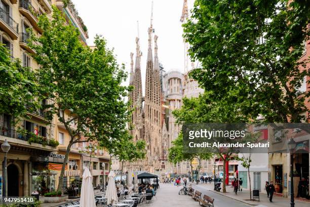 barcelona street and sagrada familia church, catalonia, spain - barcelona spanje stockfoto's en -beelden