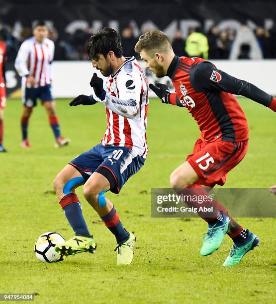 Rodolfo Pizarro of Chivas Guadalajara battles for the ball with Eriq Zavaleta of Toronto FC during the CONCACAF Champions League Final Leg 1 on April...