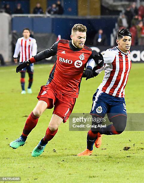 Alan Pulido of Chivas Guadalajara gets tangled up with Eriq Zavaleta of Toronto FC during the CONCACAF Champions League Final Leg 1 on April 17, 2018...