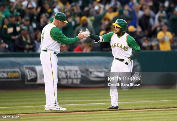 Jed Lowrie of the Oakland Athletics is congratulated by third base coach Matt Williams of the Oakland Athletics after he hit a home run in the first...