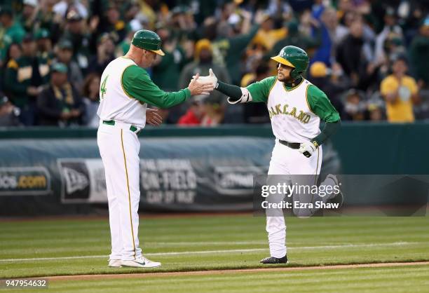 Jed Lowrie of the Oakland Athletics is congratulated by third base coach Matt Williams of the Oakland Athletics after he hit a home run in the first...