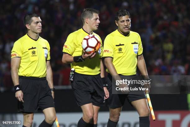 Referee German Delfino talks with his assistants Diego Bonfa and Jorge Baliño during a match between Cerro Porteño and Gremio as part of Copa...