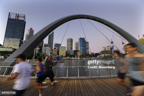 Joggers run past pedestrians on the Horseshoe Bridge in the Elizabeth Quay area of Perth, Australia, on Wednesday, April 11, 2018. Australia is...