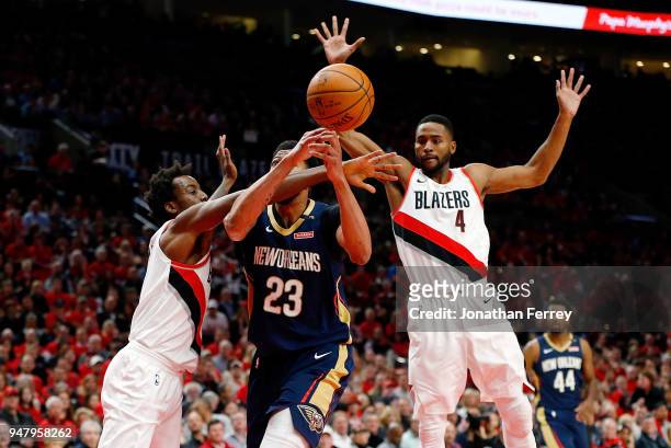 Anthony Davis of the New Orleans Pelicans is guarded by Al-Farouq Aminu and Maurice Harkless of the Portland Trail Blazers during Game One of the...
