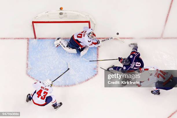 Braden Holtby of the Washington Capitals knocks the puck away from Pierre-Luc Dubois of the Columbus Blue Jackets during the first overtime period in...