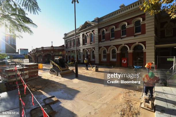 Construction workers repave an area at Perth railway station in the central business district of Perth, Australia, on Wednesday, April 11, 2018....