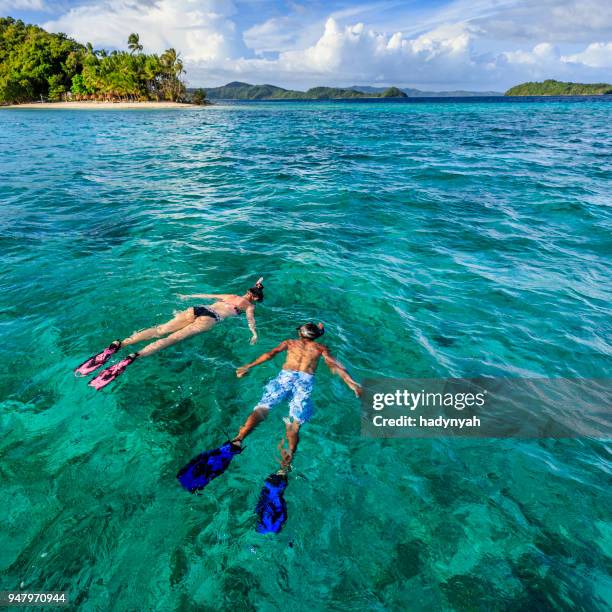 young couple snorkeling on east china sea, philippines - cebu province stock pictures, royalty-free photos & images