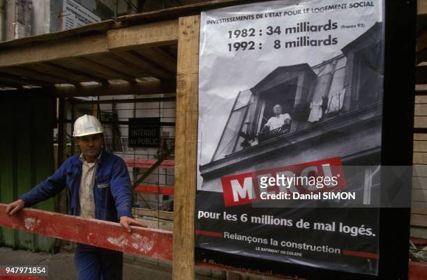 Un ouvrier sur un chantier a cote d'une affiche en faveur du logement social en novembre 1992 a Paris, France.
