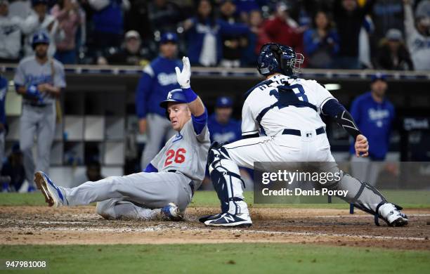 Chase Utley of the Los Angeles Dodgers slides as he scores ahead of the tag of Austin Hedges of the San Diego Padres during the 12th inning of a...