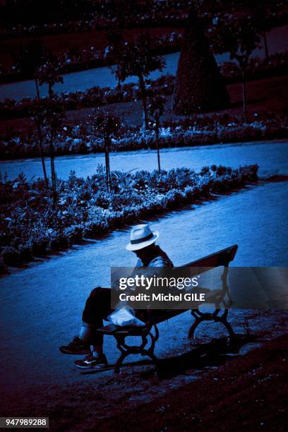 Homme avec un chapeau sur un banc du jardin des Plantes, Le Mans, France.