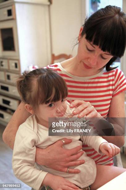 Femme faisant boire de l'eau à sa petite fille, 9 février 2011, France.