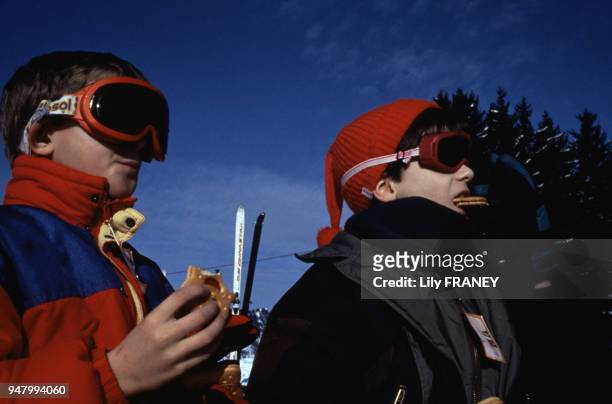 Enfants prenant le goûter au bord d'une piste de ski lors d'une colonie de vacances du Comité Central d'Entreprise de la SNCF en Savoie, en 2001,...