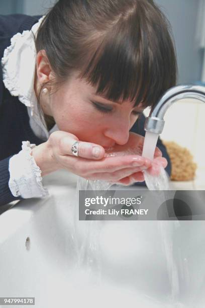 Femme buvant de l'eau au robinet, 8 février 2011, France.