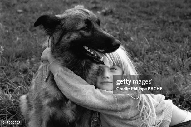 Petite fille faisant un câlin à son chien, en 1990, France.