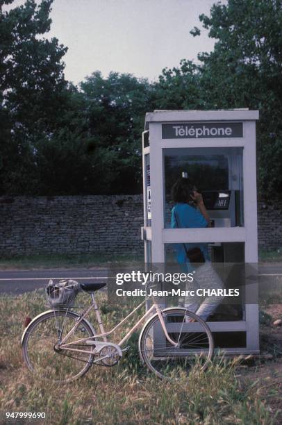 Femme téléphonant dans une cabine téléphonique sur l'île de Ré, en juillet 1987, en Charente-Maritime, France.