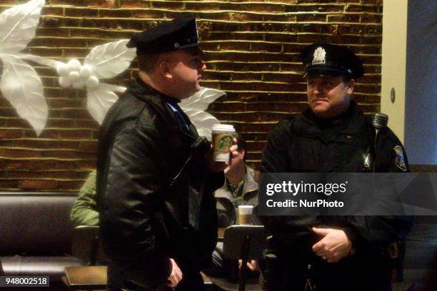 Philadelphia PD Police Officer holds a coffee cup as an estimated fifty protest at a Starbucks location in Center City Philadelphia, PA, USA on April...