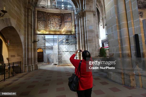 Woman takes a photo of a tapestry in the dome on a sunny and hot spring day in Bamberg, Northern Bavaria, Germany. The in Germany will be close to 30...