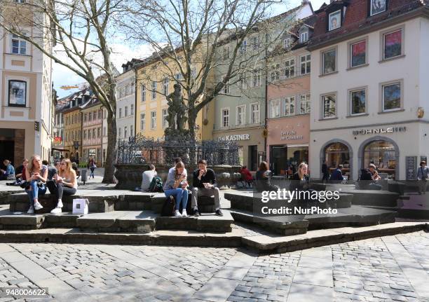 People sitting on a sunny and hot spring day in Bamberg, Northern Bavaria, Germany. The in Germany will be close to 30 degrees Celsius the next days.