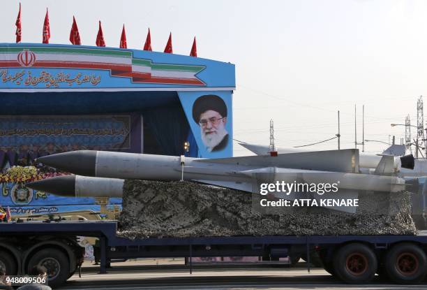 An Iranian military truck carries surface-to-air missiles past a portrait of Iran's Supreme Leader Ayatollah Ali Khamenei during a parade on the...