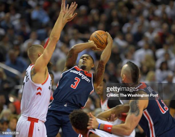 Washington guard Bradley Beal , center, tries to get a shot off during the first half in a game between the Toronto Raptors and the Washington...
