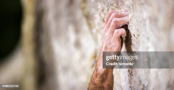 hand gripping cliff - rock face stock pictures, royalty-free photos & images