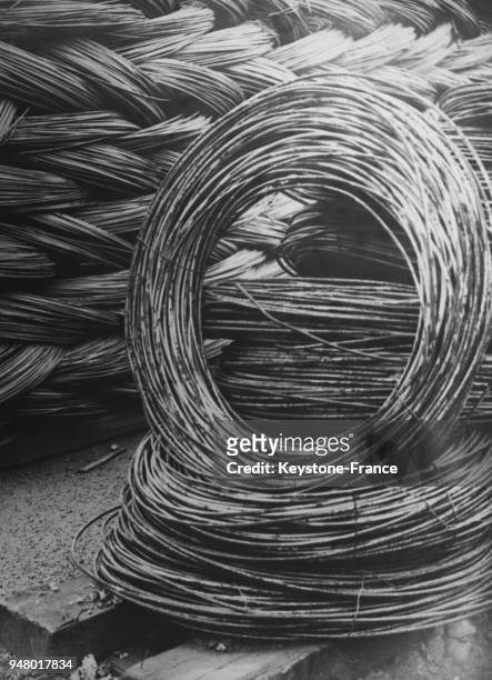 Rouleaux de fil de métal dans une fabrique de fil, en France en 1935.