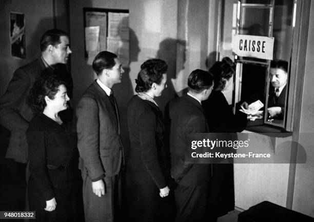 Queue au guichet d'entrée d'un cinéma, en France, circa 1950.