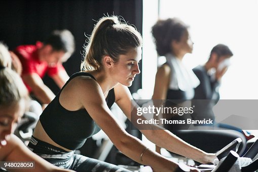High Ride Woman Riding Stationary Bike During Indoor Cycling Class In Fitness ...