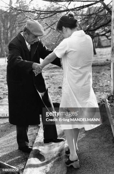 Infirmière aidant un homme âgé dans une maison de retraite, en 1984.