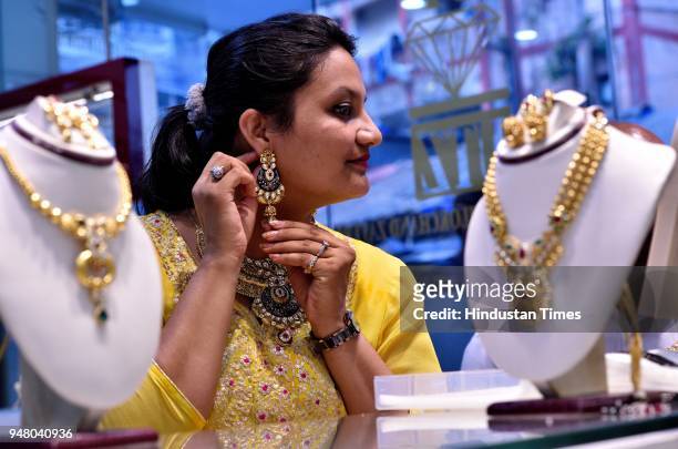 Woman tries the gold ornaments on the eve of Akshaya Tritiya at Jewellery Shop at Kalbhadevi, on April 17, 2018 in Mumbai, India. Akshaya Tritiya,...
