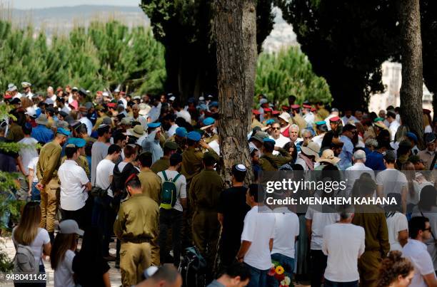Israeli mourners observe two minutes of silence near the graves of Israeli soldiers during a Remembrance Day ceremony at the Mount Herzl military...