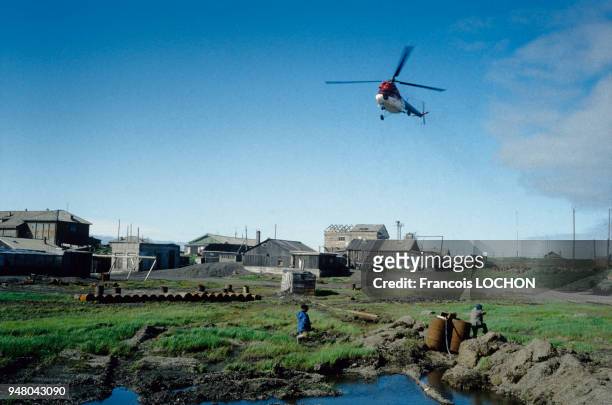 Hélicoptère au-dessus d'un village de l'île Itouroup dans l'archipel des Kouriles en juillet 1993, Russie.