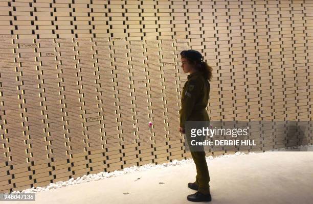An Israeli soldier looks at the names of fallen soldiers in the National Memorial Hall For Israel's Fallen before the official ceremony for Israel's...