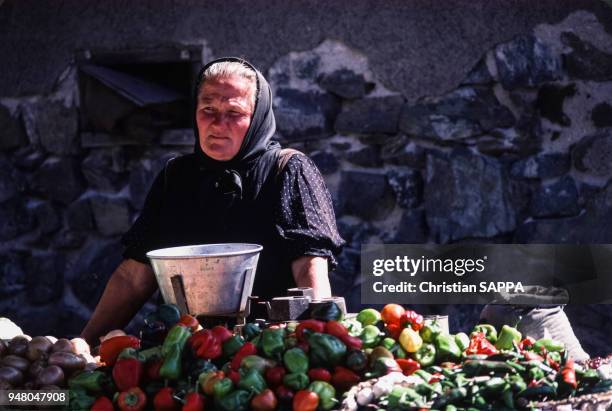 Vendeuse de légume sur le marché dans la région de Cluj-Napoca, en septembre 1983, Roumanie.