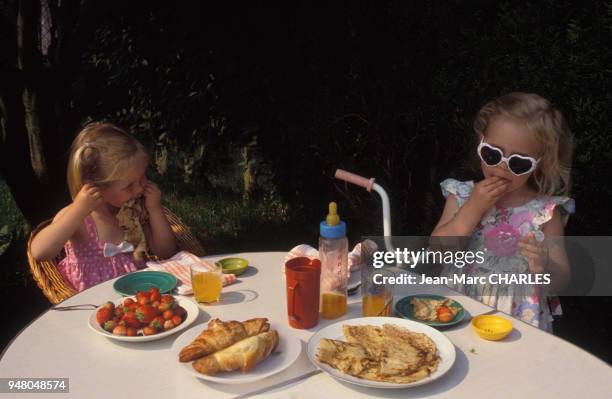 Petites filles prenant le goûter dans un jardin, en juillet 1988.