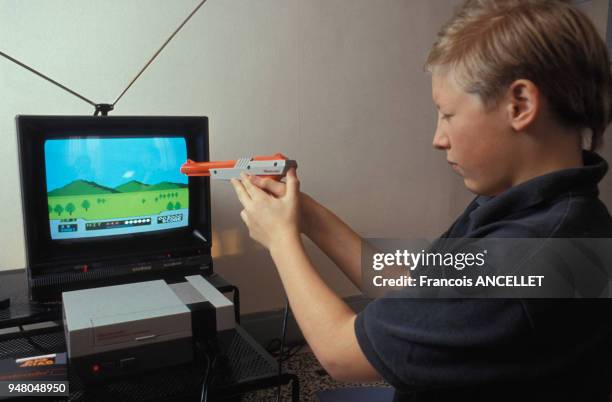 Enfant jouant avec un console de jeux video, en 1992.